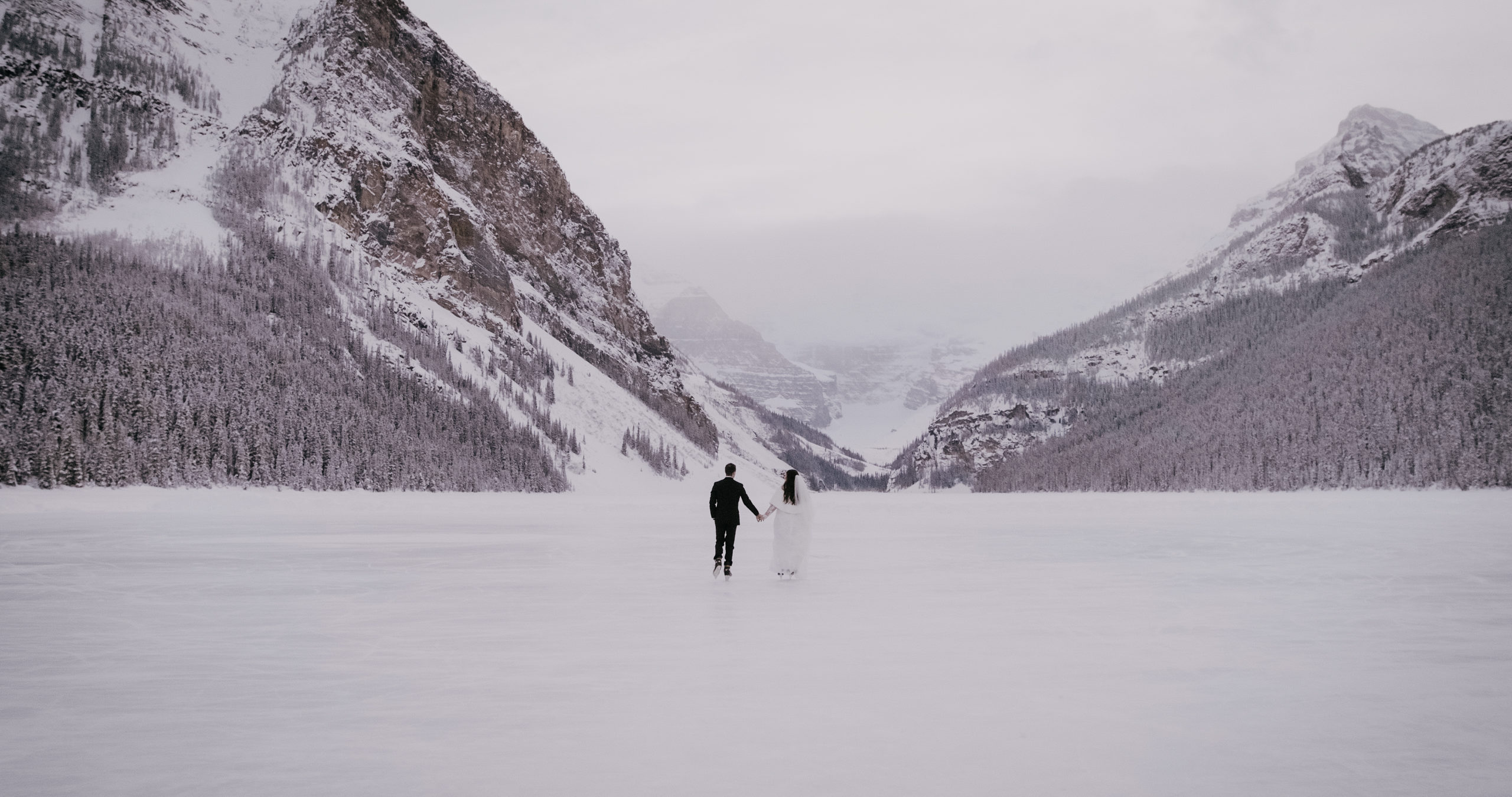 Couple skating on Lake Louise during their wedding day in Banff national park.