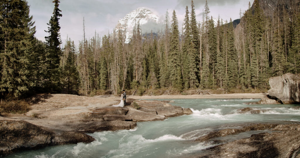 Couple embracing at the natural bridge inside yoho national park